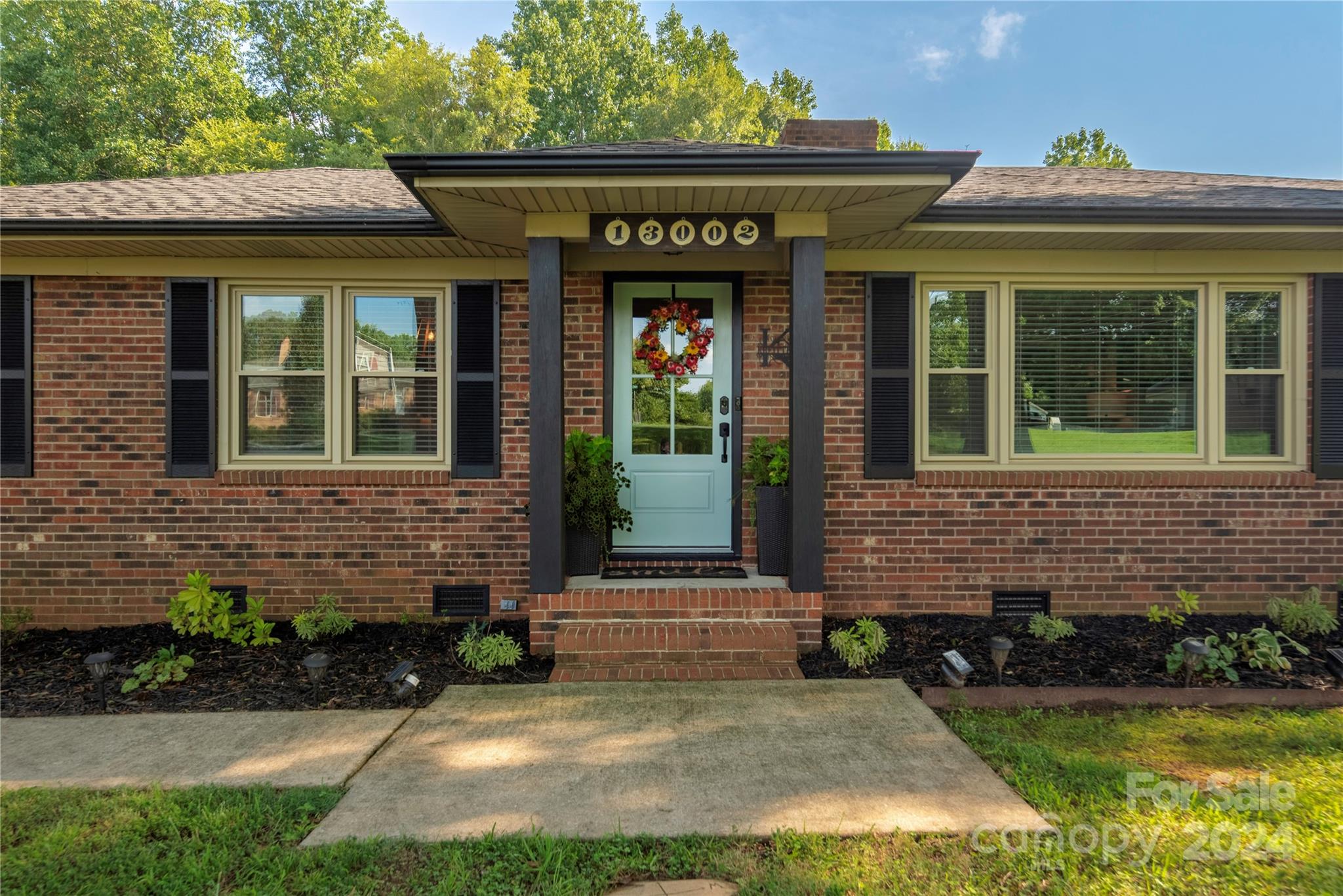 13002 Mayes Road Huntersville, NC 28078 - Photo 3 of 43 a view of a brick house with a yard potted plants and a table