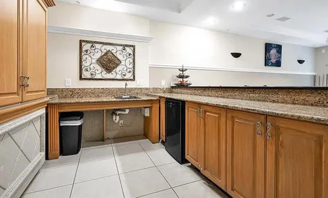 a view of a patio with plants and chairs under an umbrella