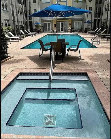 a view of backyard with table and chairs with potted plants