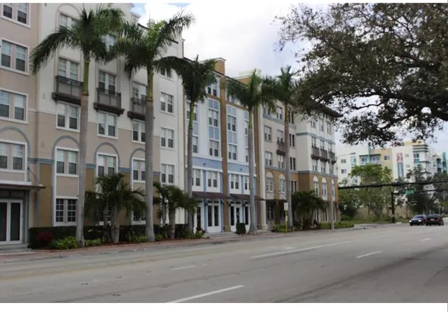 a city street lined with tall buildings and a yard