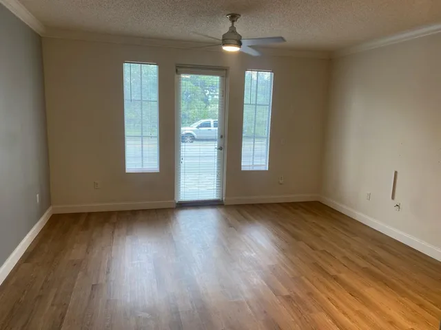 an empty room with wooden floor and windows