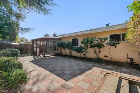a view of a patio with table and chairs and potted plants