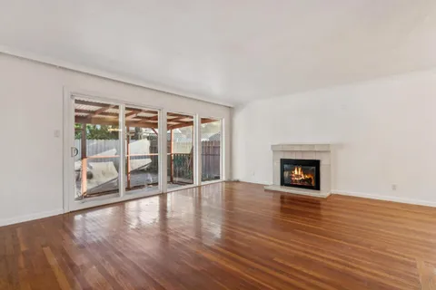 an empty room with wooden floor and fireplace