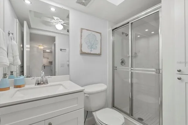 a bathroom with a toilet a sink and glass door