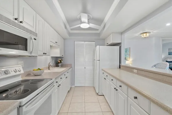a kitchen with white cabinets and white appliances