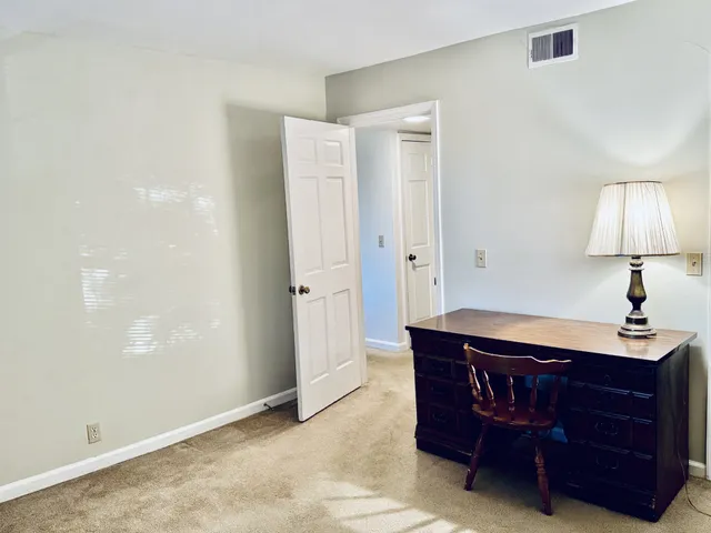 a room with a dresser and a lamp