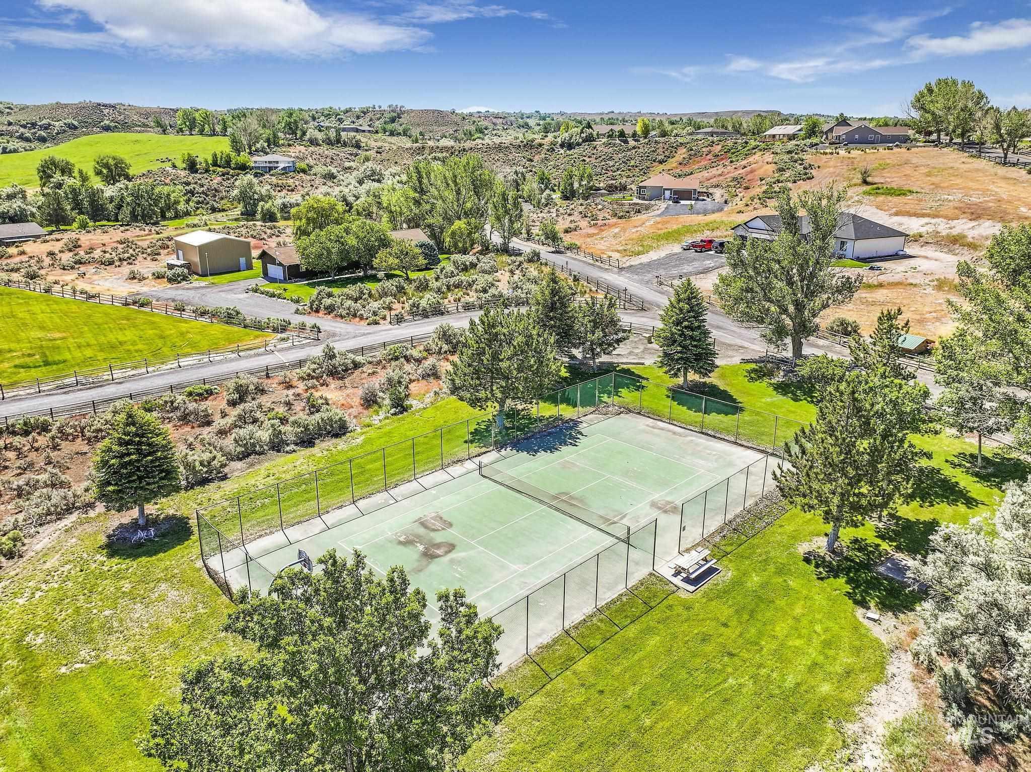 4485 Silver Creek Road Buhl, ID 83316 - Photo 46 of 49 Private tennis court with surrounding fencing, bordered by mature trees and manicured lawns