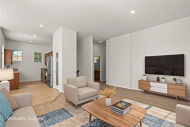 a view of a big room with wooden floor and a kitchen