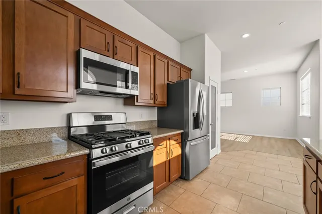 a kitchen with granite countertop a sink stainless steel appliances a counter space and a window