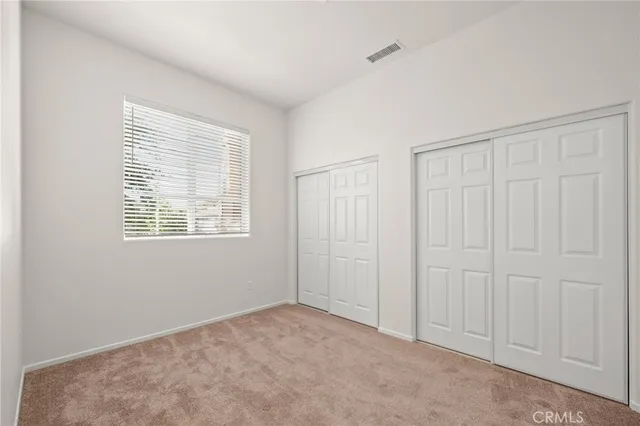 a bathroom with a granite countertop double vanity and a mirror