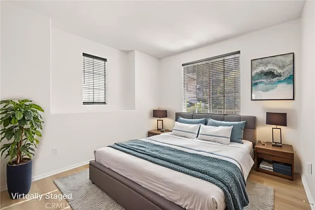 a bedroom with a large bed and a potted plant