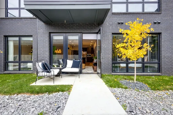a view of a patio with table and chairs near a barbeque