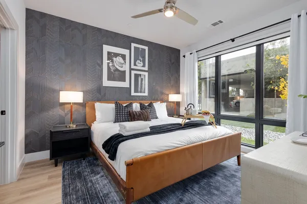 a large bedroom with bed and wooden floor