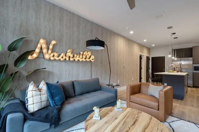 a large kitchen with stainless steel appliances a stove a sink dishwasher and a refrigerator with wooden floor