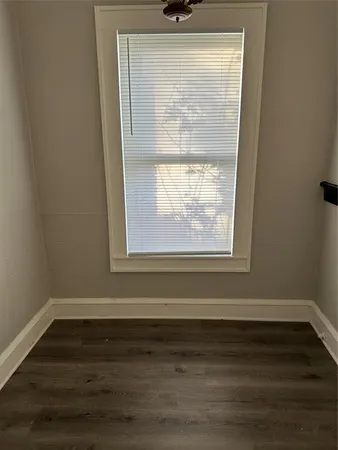 a view of a small space with wooden floor and a window