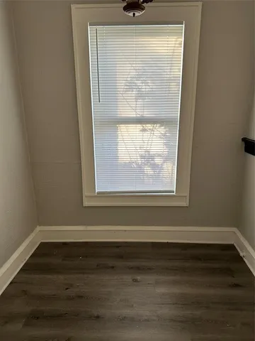 a view of a small space with wooden floor and a window