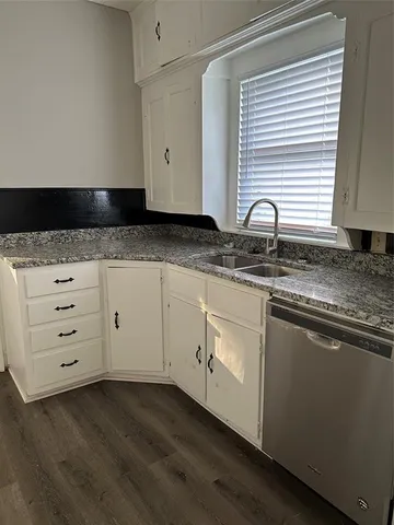 a kitchen with granite countertop white cabinets and a sink