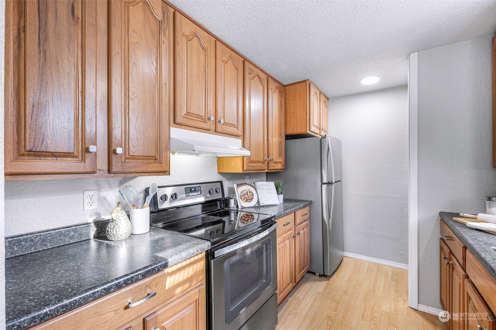 18216 22nd Drive Southeast Bothell, WA 98012 - Photo 17 of 40 a kitchen with stainless steel appliances granite countertop a refrigerator a sink dishwasher a stove and white countertops with wooden floor