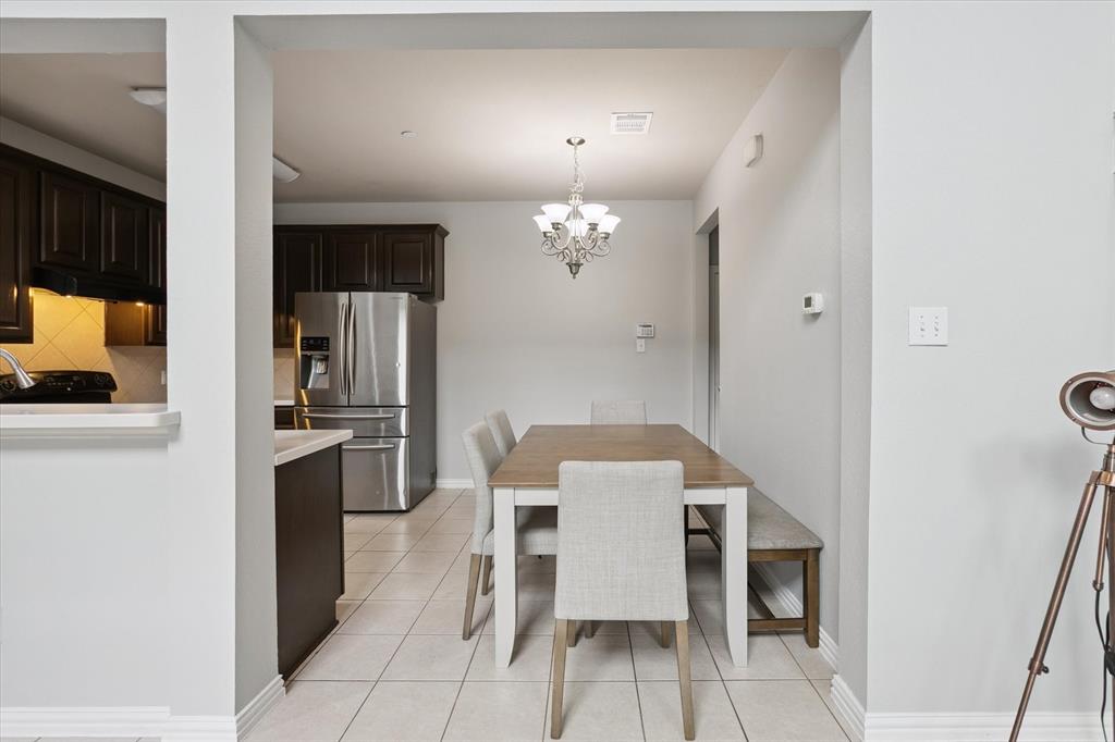 2202 Sandshell Street Bedford, TX 76021 - Photo 11 of 40 Dining space with light tile patterned flooring and a chandelier