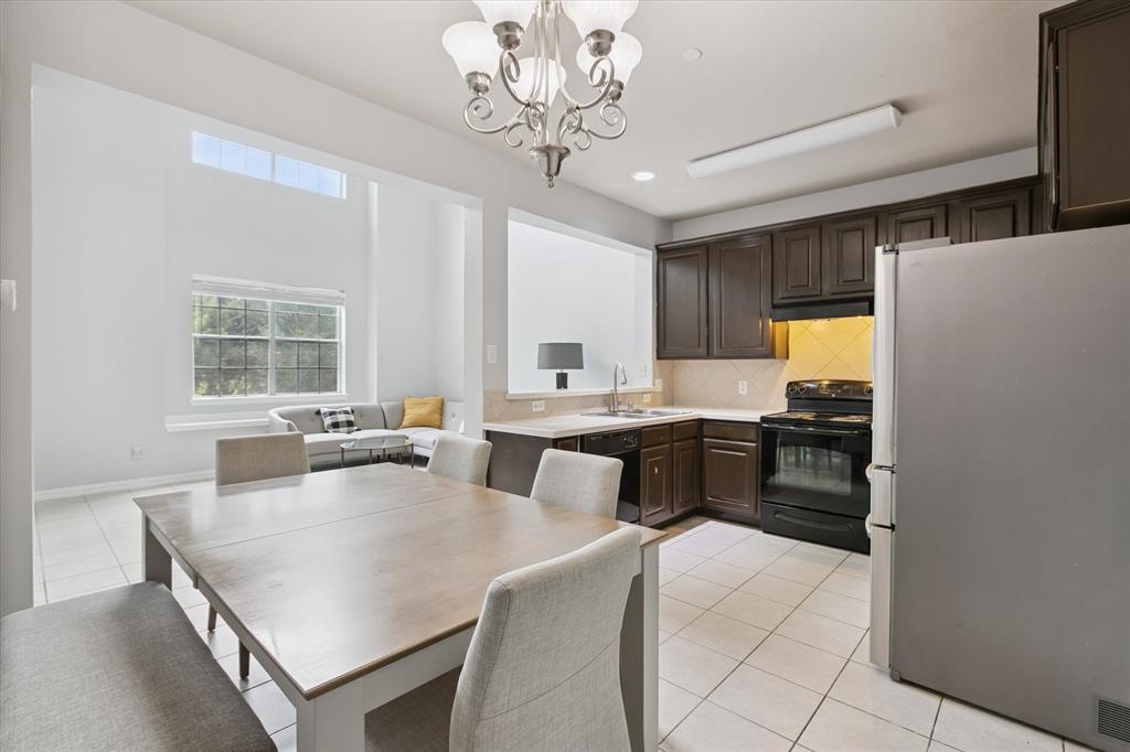 2202 Sandshell Street Bedford, TX 76021 - Photo 13 of 40 Kitchen with light countertops, black appliances, light tile patterned flooring, dark brown cabinetry, and tasteful backsplash