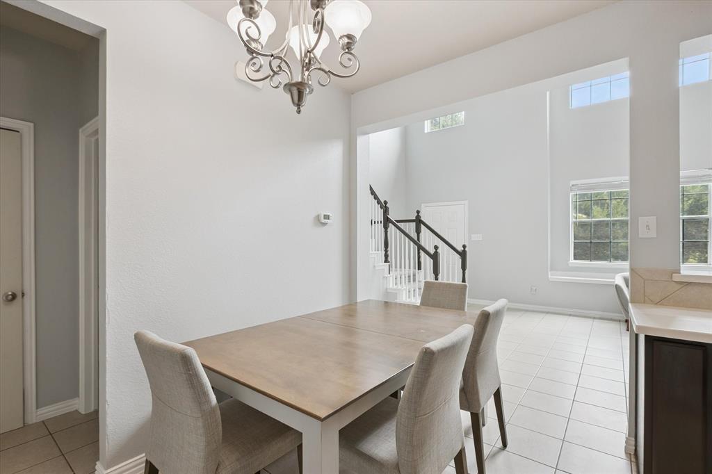 2202 Sandshell Street Bedford, TX 76021 - Photo 14 of 40 Dining room with light tile patterned flooring, stairs, and a chandelier