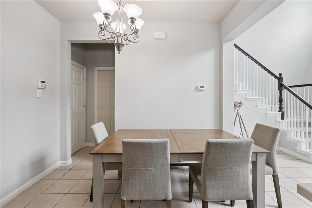 2202 Sandshell Street Bedford, TX 76021 - Photo 15 of 40 Dining room featuring light tile patterned floors, a chandelier, and stairway