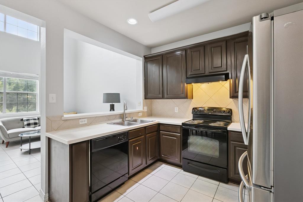 2202 Sandshell Street Bedford, TX 76021 - Photo 16 of 40 Kitchen featuring dark brown cabinetry, black appliances, light countertops, light tile patterned flooring, and recessed lighting