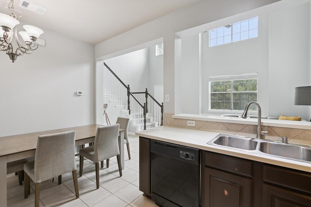 2202 Sandshell Street Bedford, TX 76021 - Photo 20 of 40 Kitchen with dishwasher, dark brown cabinetry, light countertops, light tile patterned floors, and pendant lighting
