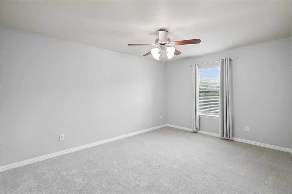 2202 Sandshell Street Bedford, TX 76021 - Photo 22 of 40 Empty room with light colored carpet and ceiling fan