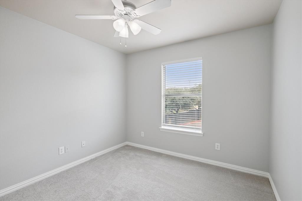 2202 Sandshell Street Bedford, TX 76021 - Photo 32 of 40 Carpeted spare room featuring baseboards and a ceiling fan