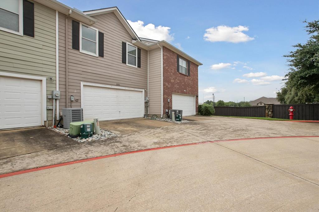 2202 Sandshell Street Bedford, TX 76021 - Photo 38 of 40 View of property exterior featuring an attached garage, concrete driveway, and brick siding