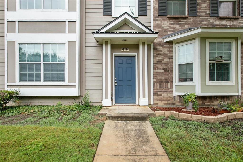 2202 Sandshell Street Bedford, TX 76021 - Photo 5 of 40 Doorway to property with brick siding and a yard