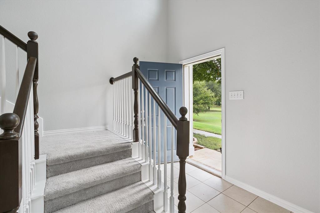 2202 Sandshell Street Bedford, TX 76021 - Photo 6 of 40 Stairway featuring tile patterned floors and a high ceiling
