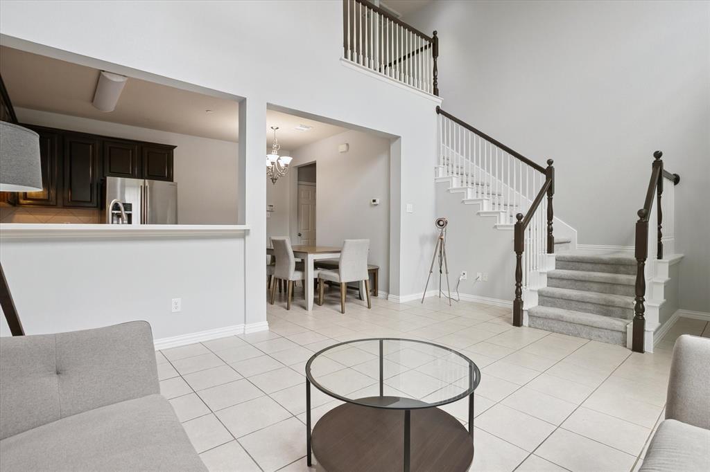 2202 Sandshell Street Bedford, TX 76021 - Photo 7 of 40 Living room with light tile patterned floors, stairway, a high ceiling, and a chandelier