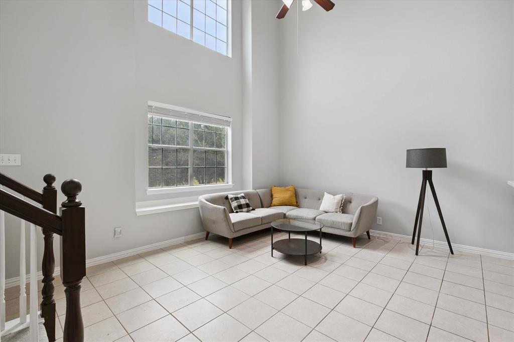 2202 Sandshell Street Bedford, TX 76021 - Photo 8 of 40 Living area featuring a high ceiling, light tile patterned floors, ceiling fan, and stairs