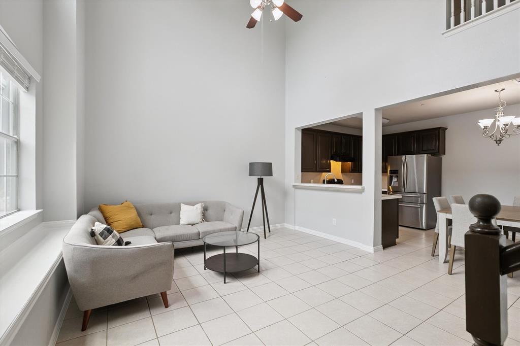 2202 Sandshell Street Bedford, TX 76021 - Photo 9 of 40 Living area featuring a towering ceiling, a ceiling fan, light tile patterned floors, and a chandelier