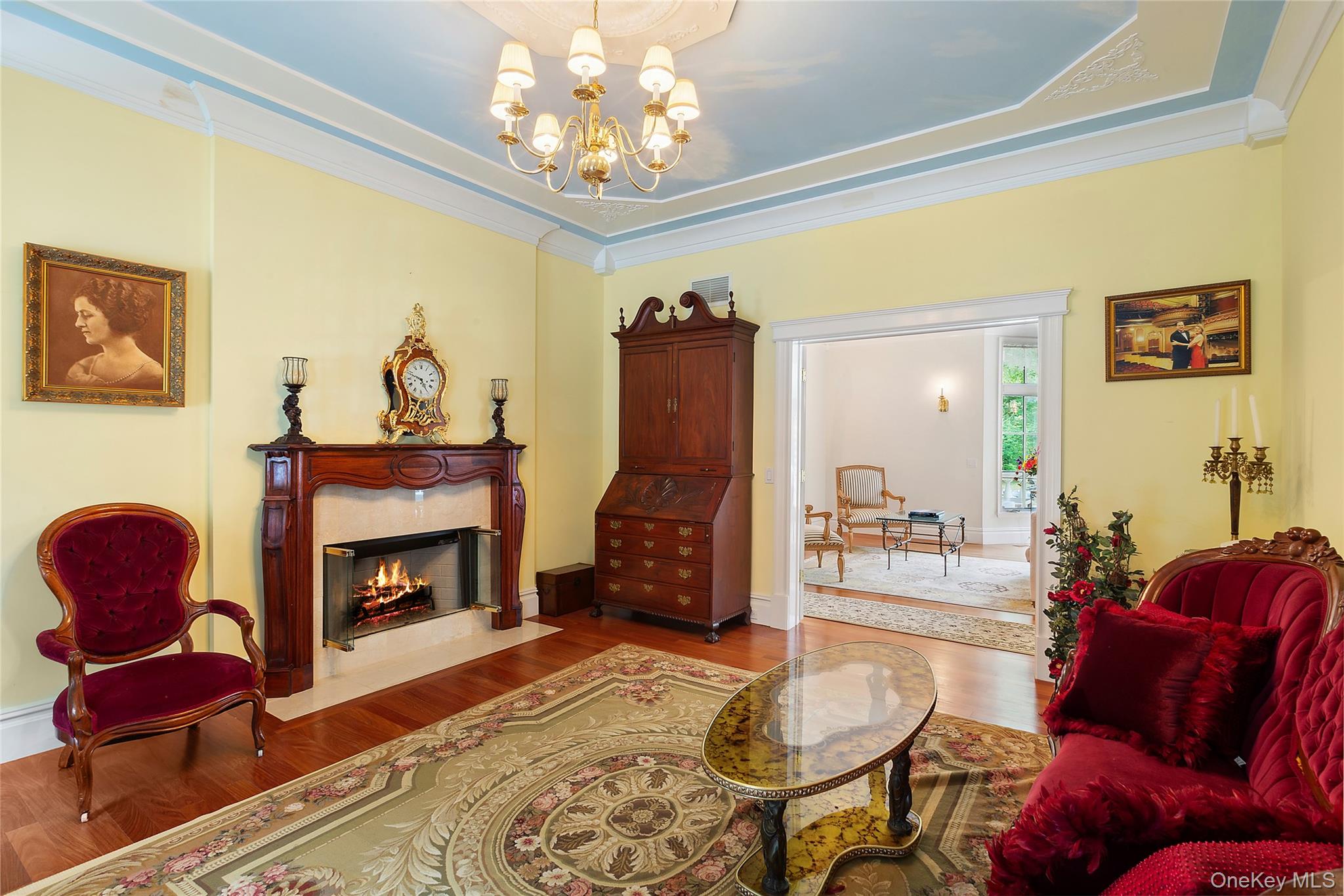 1 Terrys Trail East Hampton, NY 11937 - Photo 17 of 25 Living area with a chandelier, a fireplace, wood finished floors, crown molding, and a tray ceiling
