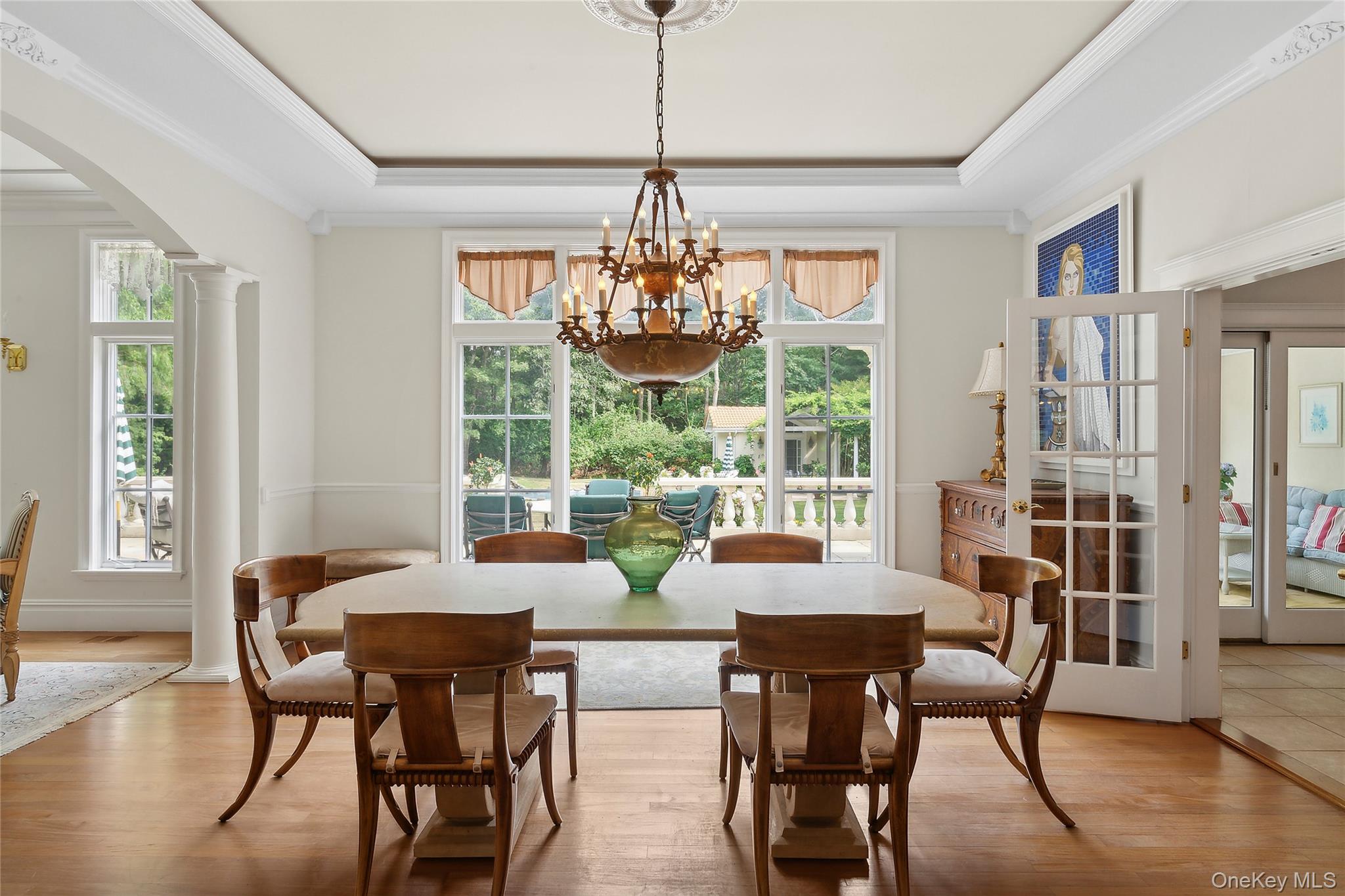 1 Terrys Trail East Hampton, NY 11937 - Photo 18 of 25 Dining room featuring arched walkways, wood finished floors, crown molding, healthy amount of natural light, and ornate columns