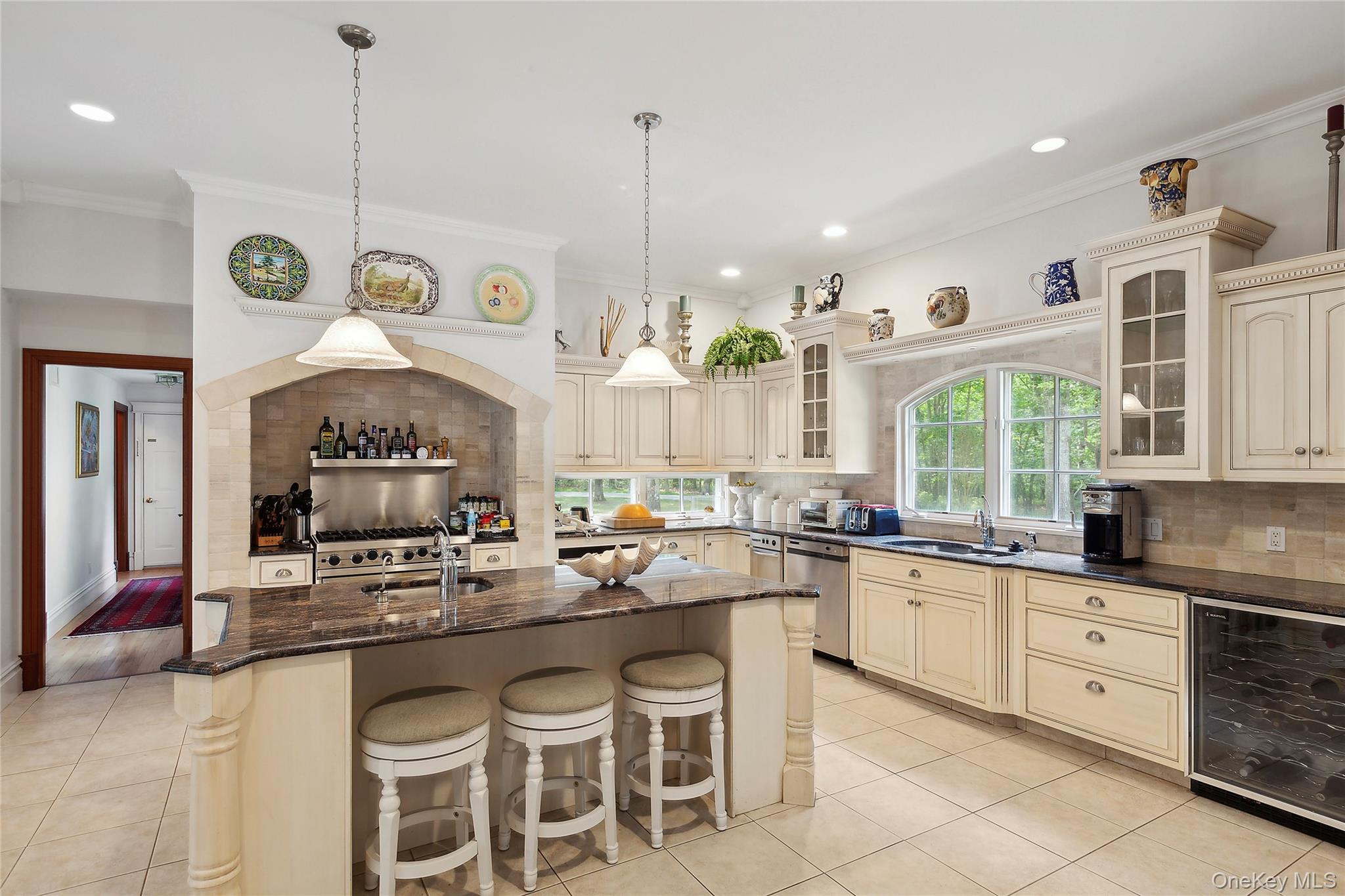 1 Terrys Trail East Hampton, NY 11937 - Photo 20 of 25 Kitchen featuring cream cabinets, beverage cooler, backsplash, hanging light fixtures, and crown molding