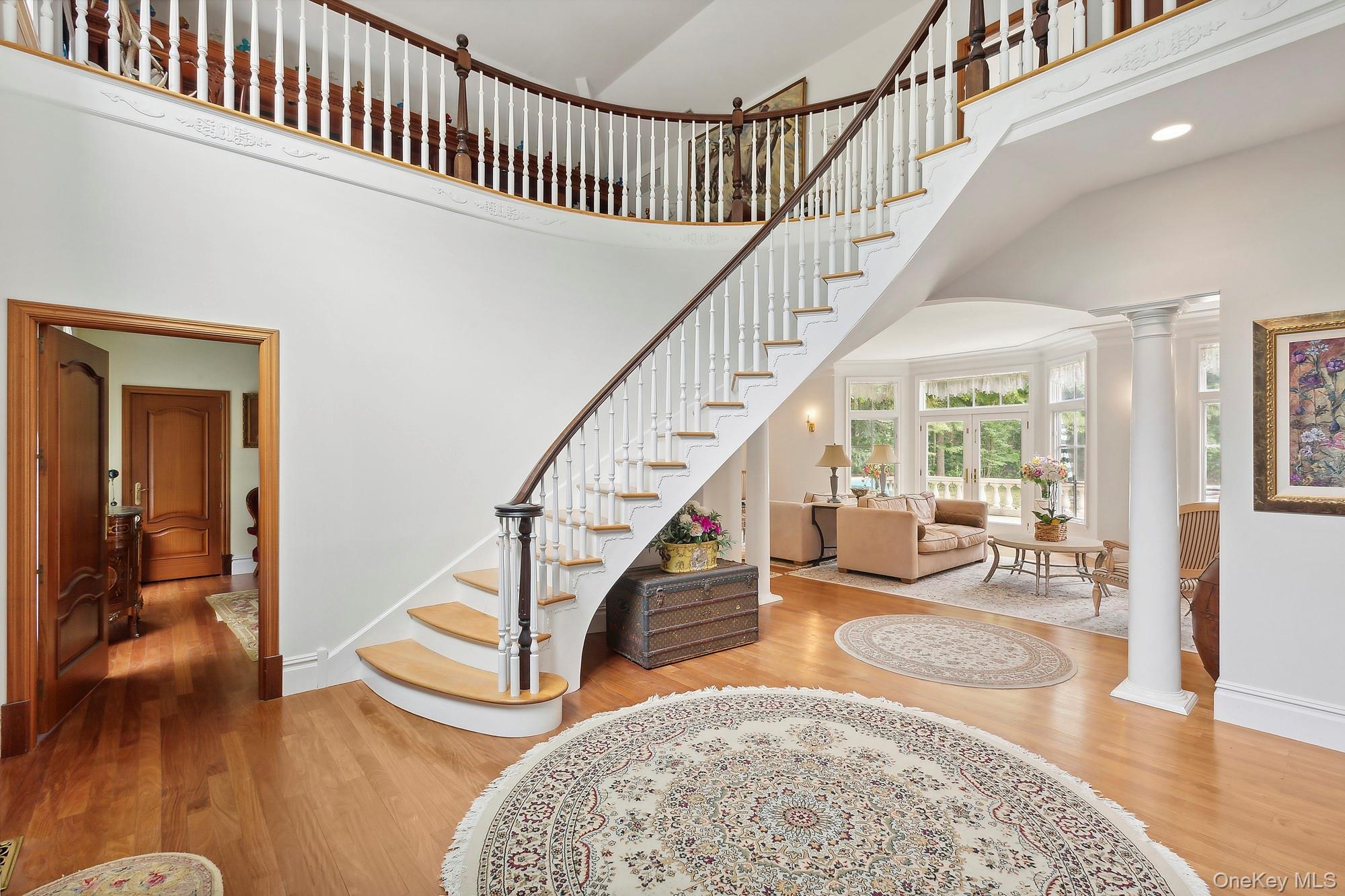1 Terrys Trail East Hampton, NY 11937 - Photo 5 of 25 Staircase with a towering ceiling, wood finished floors, and decorative columns