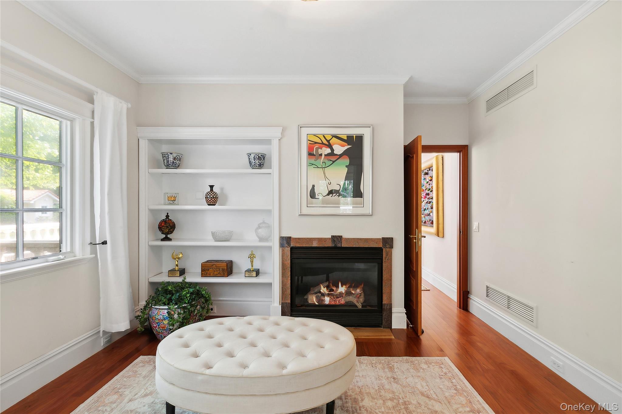1 Terrys Trail East Hampton, NY 11937 - Photo 8 of 25 Sitting room featuring wood finished floors, crown molding, a glass covered fireplace, and built in features