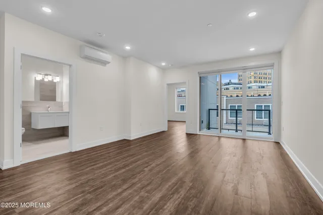 a view of a big room with wooden floor and a bathroom