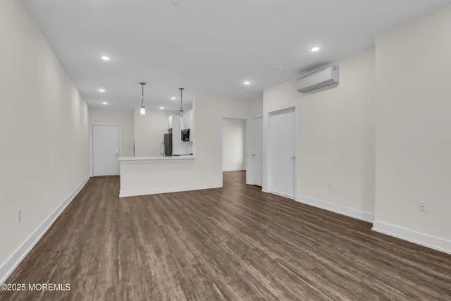 a view of a big room with wooden floor and windows
