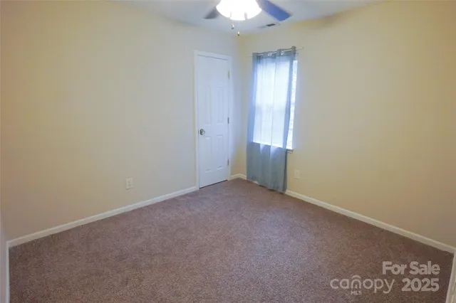 an empty room with a chandelier fan