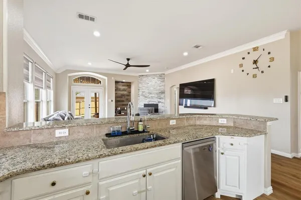a kitchen with granite countertop stainless steel appliances a sink stove top oven and cabinets