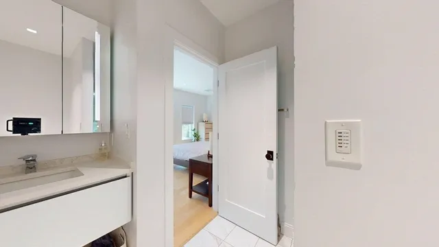 a en suite bathroom with a granite countertop sink and a mirror