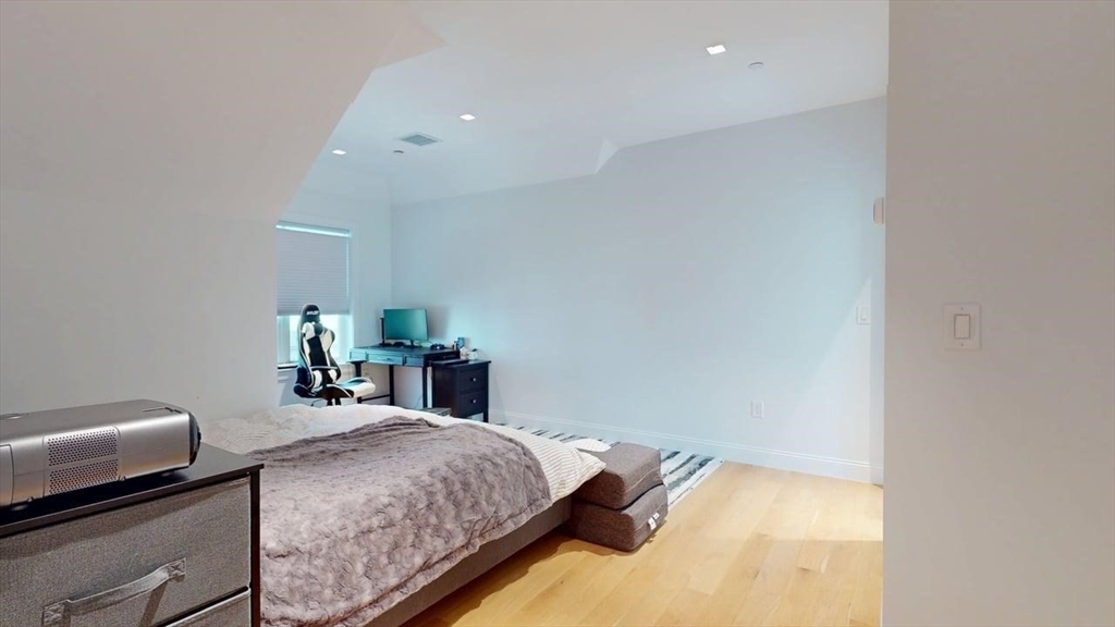 21 Crowninshield Road, Unit 17 Brookline, MA 02446 - Photo 17 of 29 a bedroom with a bed and a lamp on dresser