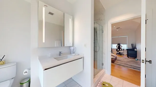 a en suite bathroom with a granite countertop sink and a mirror