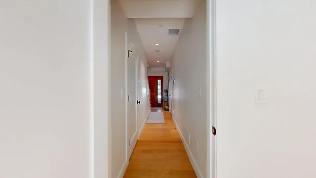 a view of a hallway with wooden floor