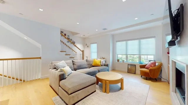 a living room with furniture a flat screen tv and a large window